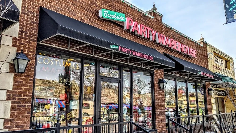 Brookside Party Warehouse's red-and-green sign above the black awnings and glass entrance at number 103.