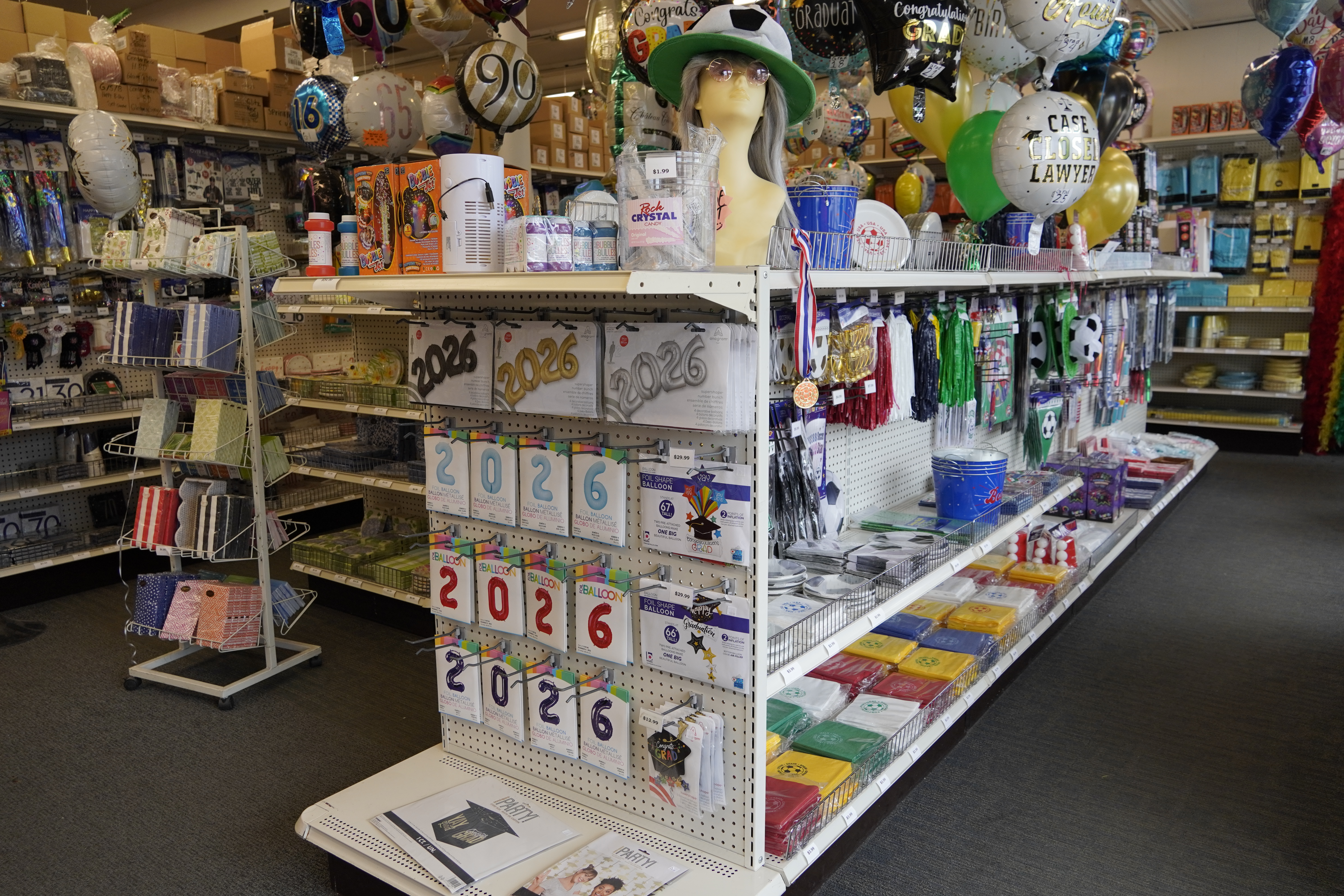 Floor-to-ceiling shelves of themed party tableware and decorations at Brookside Party Warehouse.