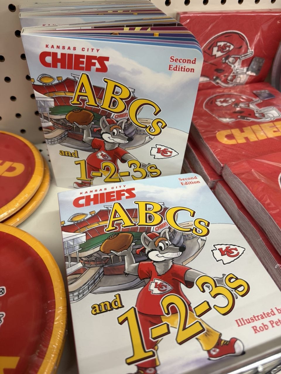 Kansas City Chiefs ABC books and red party napkins on a store shelf.