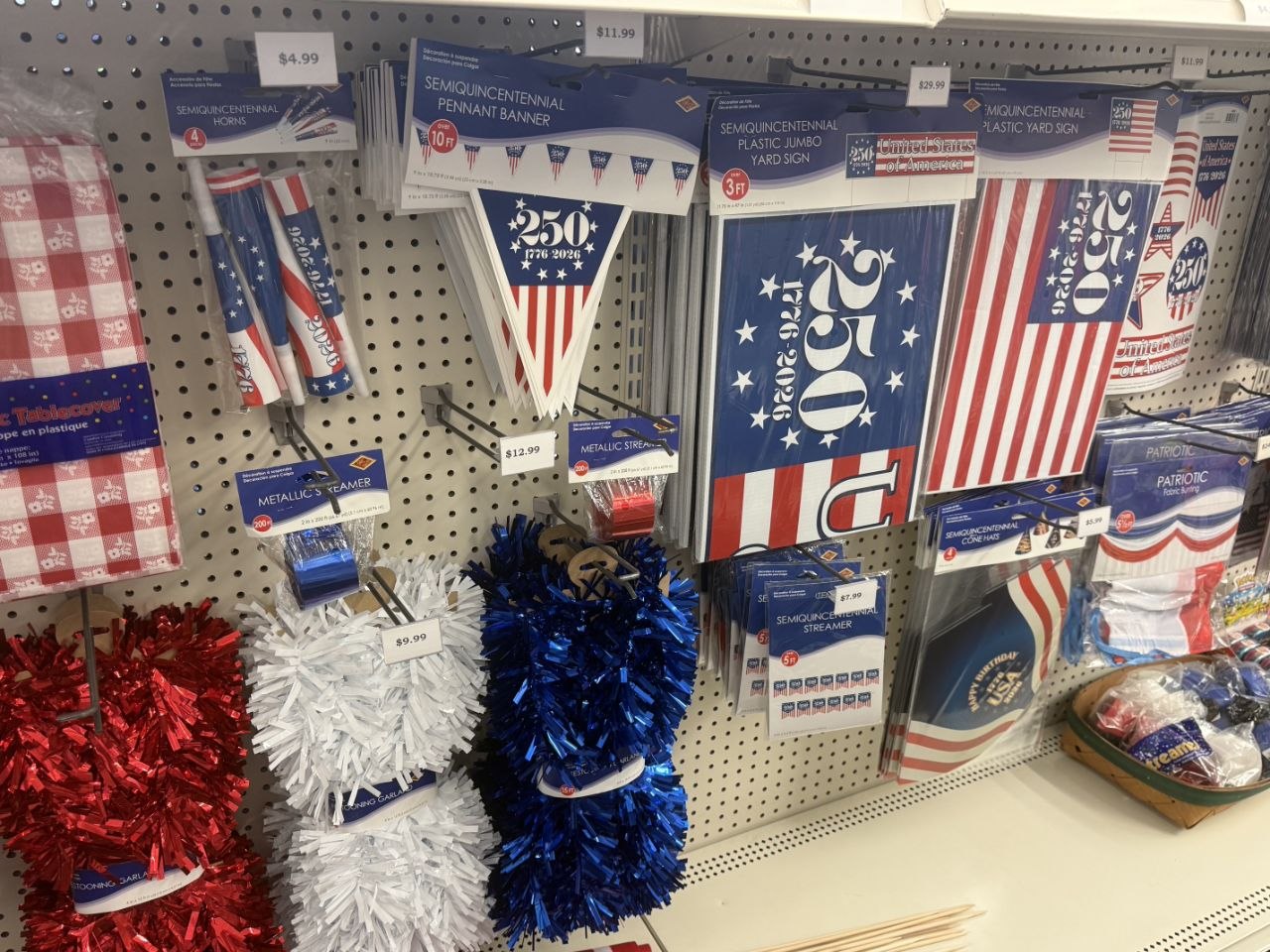 Semiquincentennial banners, yard signs, horns, streamers, and red, white, and blue garland.