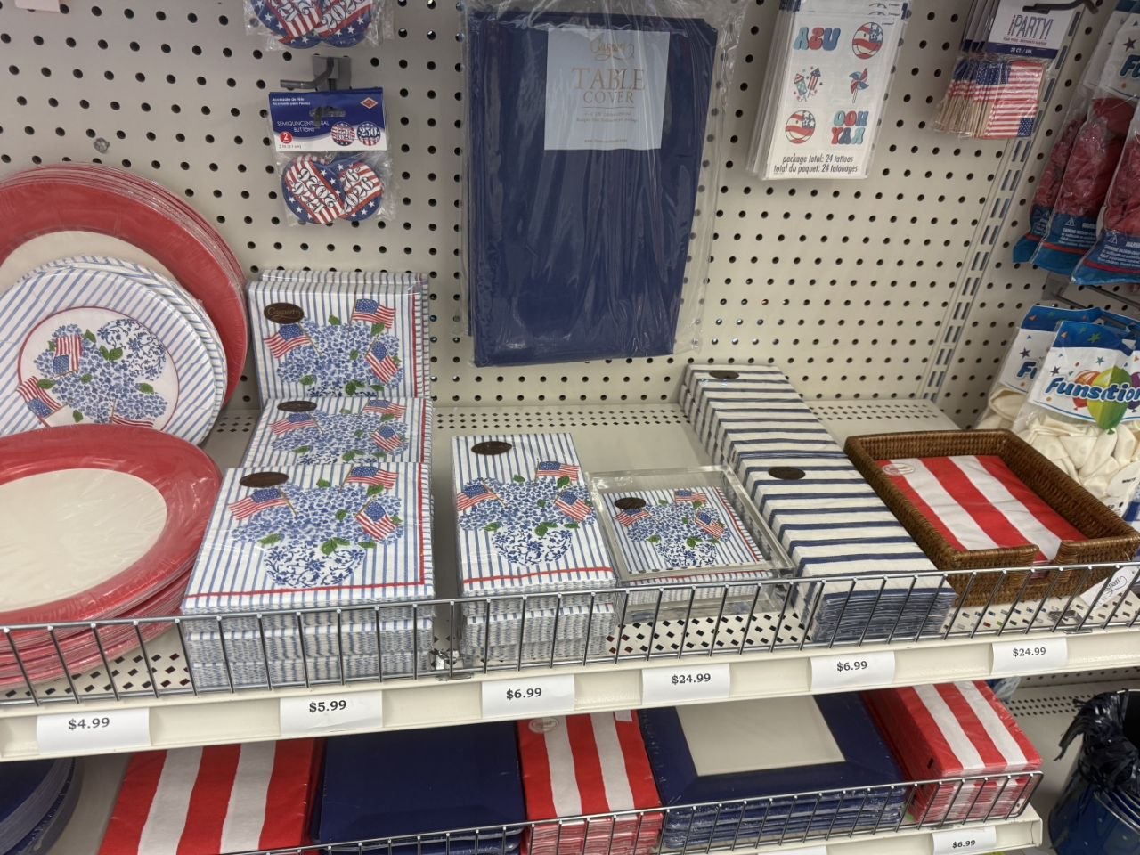 Patriotic plates, napkins, table covers, and party tableware on store shelves.